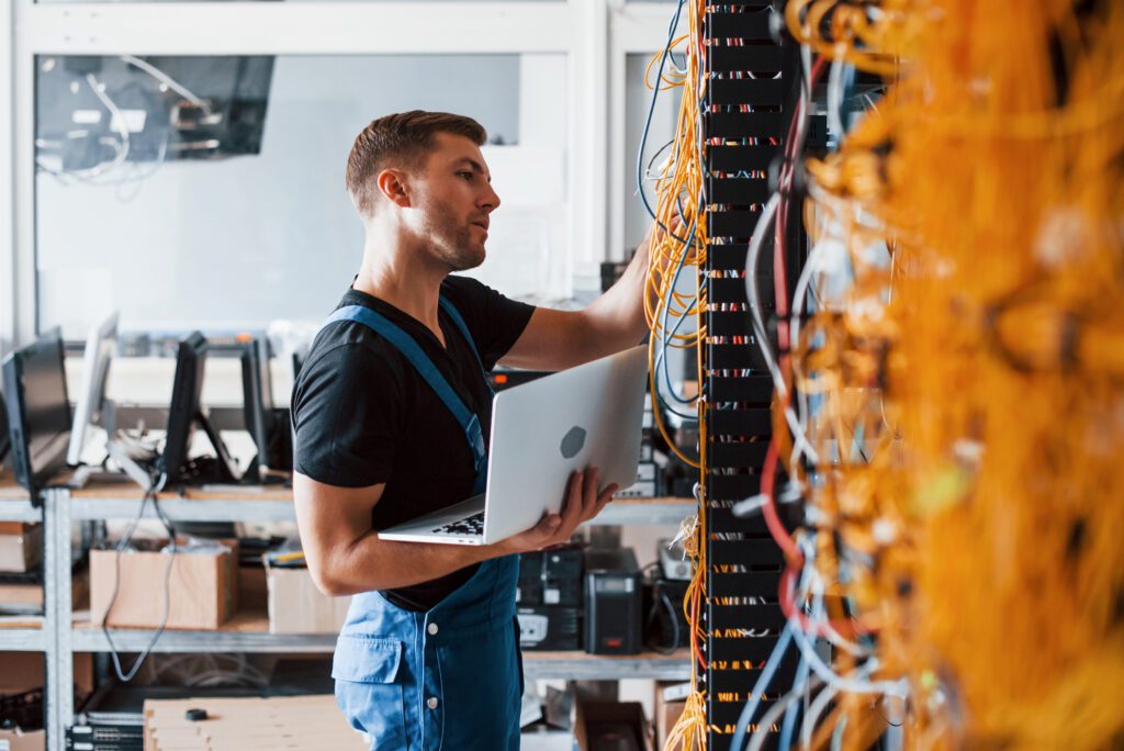 man working at wall of computer servers